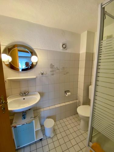 a bathroom with a sink and a toilet and a mirror at Ferienwohnung WACHE im HAUS GERLACH in Walkenried
