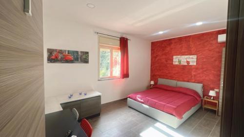1 dormitorio con cama roja y pared roja en Etna &Vita, en San Giovanni la Punta