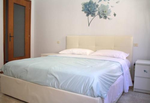 ein weißes Bett mit weißer Bettwäsche und Kissen in der Unterkunft casa bilocale in centro vicino stazione in Voghera
