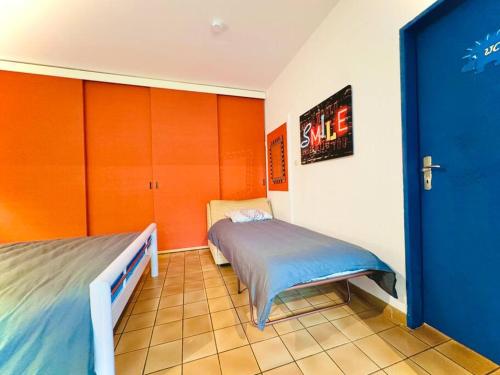 1 dormitorio con 2 camas y armarios anaranjados y azules en Skyview Studio Peaceful Retreat near Luxemburg Airport, en Niederanven