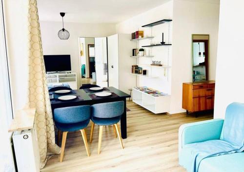a living room with a table and blue chairs at Sonniges Apartment in ruhiger und zentraler Lage in Pforzheim
