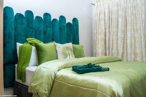 a bedroom with a bed with green pillows at Emerald Gem-Luxury Apartment in Sandton