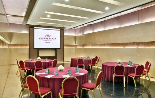 a conference room with purple tables and chairs and a screen at Crowne Plaza Amman by IHG in Amman