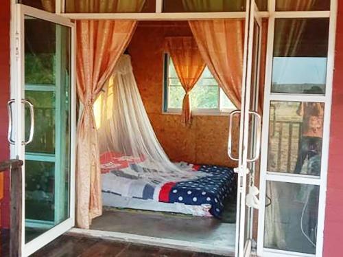 um quarto com uma cama num quarto com janelas em Banrai Tator Phophiang em Ban Nong Khan