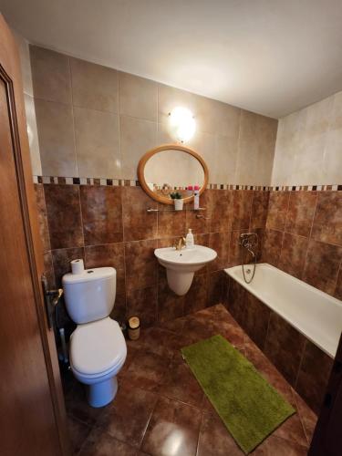 a bathroom with a toilet and a sink and a tub at Grand Central House in Odorheiu Secuiesc