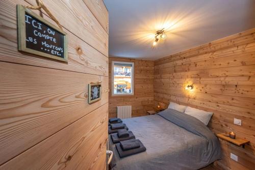 une chambre avec un lit et un panneau sur le mur dans l'établissement LE TRONADOR - 2 pièces au pied des pistes, à Orcières