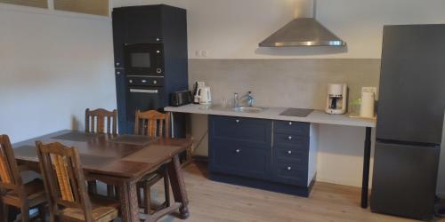 une cuisine avec une table en bois et une cuisine avec une salle à manger dans l'établissement Appartements simples et fonctionnels, à Pamiers