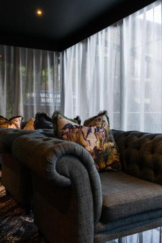 a couch sitting in front of a window with curtains at Park hall Hotel & Spa Lancashire, a member of Radisson Individuals in Eccleston