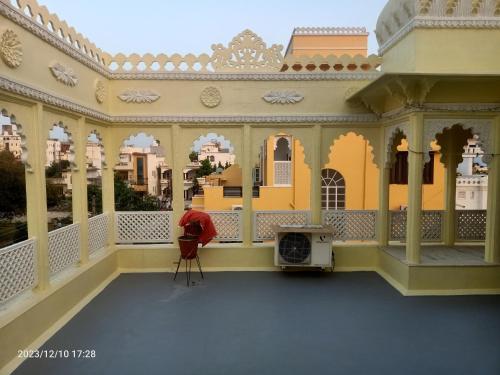 uma pessoa sentada na varanda de um edifício em Gokulam Villa em Udaipur