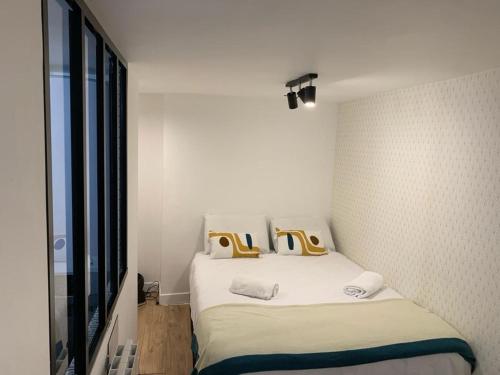 150 - Urban Pretty Flat in Center of Paris في باريس: غرفة نوم عليها سرير ووسادتين