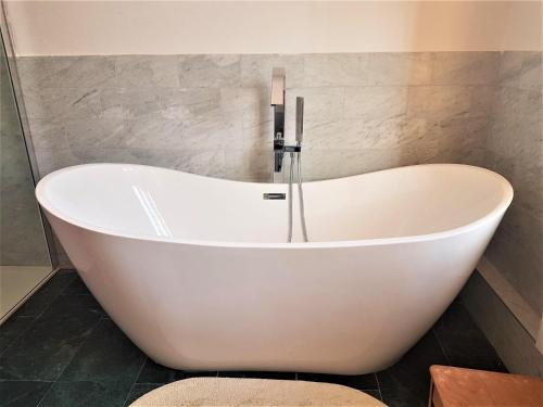 a white bath tub sitting in a bathroom at Superior-Komfort-Suite-90m2-bis-5-Personen-im-Jugendstil-Gruenderzeit-Villa-im-Harz in Sankt Andreasberg