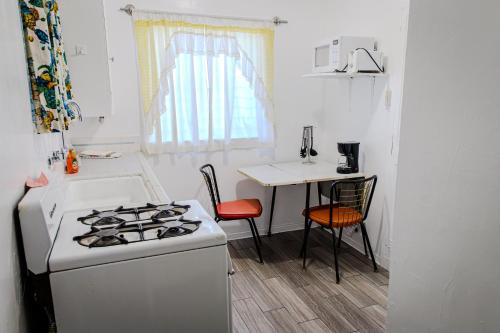 a kitchen with a stove and a table with chairs at Aloha Hotel Palm Springs in Palm Springs