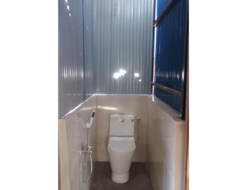 - une salle de bains avec des toilettes blanches dans une cabine dans l'établissement Hearth of Imphal, Manipur, à Imphal