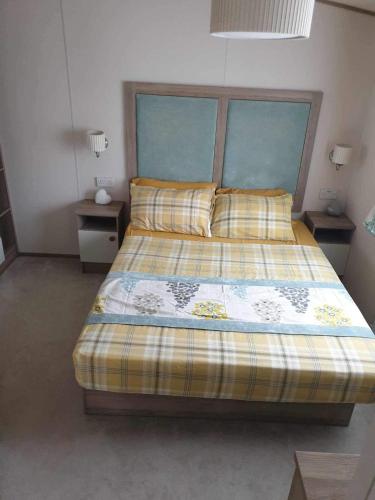 um quarto com uma cama e duas mesas de cabeceira em hot tub luxury caravan 23 Lancaster tattershall lakes em Tattershall