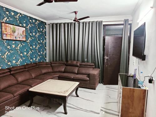 a living room with a couch and a table at Osho home in Lucknow