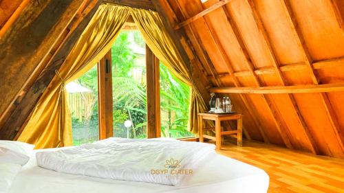 a bed in a room with a large window at New DGYP Ciater Resort in Ciater