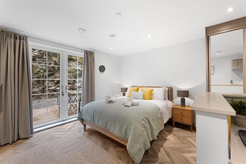 ein Schlafzimmer mit einem Bett und einem großen Fenster in der Unterkunft Rock Mill Apt 3 with Terrace in Stony Middleton