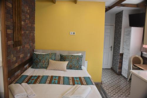 a bedroom with a bed with a yellow wall at The Han in Istanbul