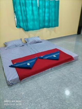a bed with two blue napkins on top of it at Gokarna Outskirt Stays in Kumta