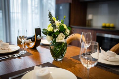 a vase of flowers sitting on a wooden table at Luxury Pentstudio Westlake - Tay Ho, Ha Noi in Hanoi