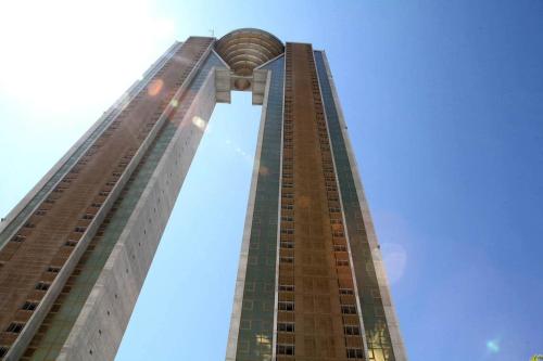 a tall building with a blue sky in the background at sky intempo resort & spa Benidorm apartment in Benidorm