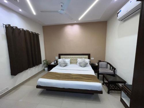 a bedroom with a large bed and a chair at Hotel The Benz in Chandīgarh