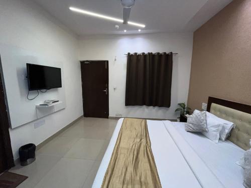 a bedroom with a bed with a television and a window at Hotel The Benz in Chandīgarh