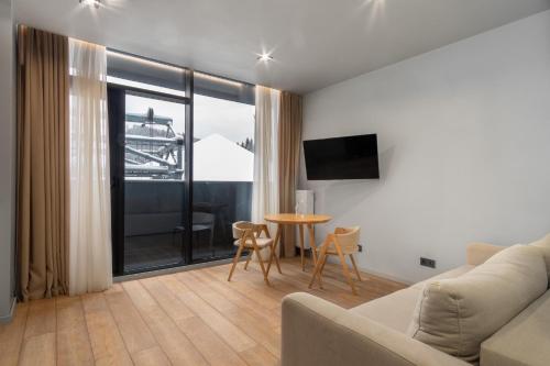 a living room with a couch and a table at SAVOIE Apartments Bukovel in Bukovel