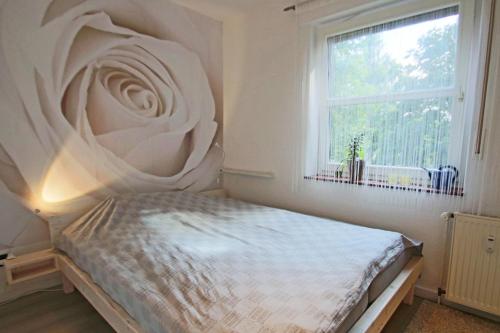 ein Schlafzimmer mit einem Bett mit einem großen Fenster in der Unterkunft Ruhiges & gemütliches Apartment im Herzen von Hüde 300 m entfernt vom Dümmer See in Hüde