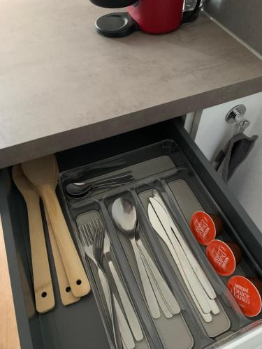 un cajón en una cocina con utensilios en Élégant F2 luxueux proche Suisse, en Delle