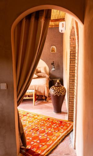 a room with a large vase in a room with a mirror at Dar Sofar in Agdz
