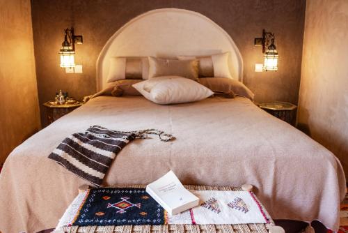 a bedroom with a bed with a book on it at Dar Sofar in Agdz