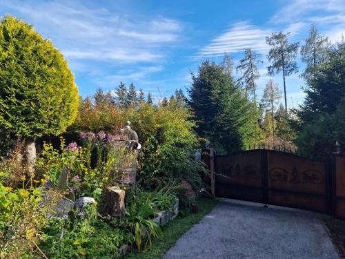 a garden with a wooden fence and flowers at Knusperhäuschen Maria Nikoletta in Witra