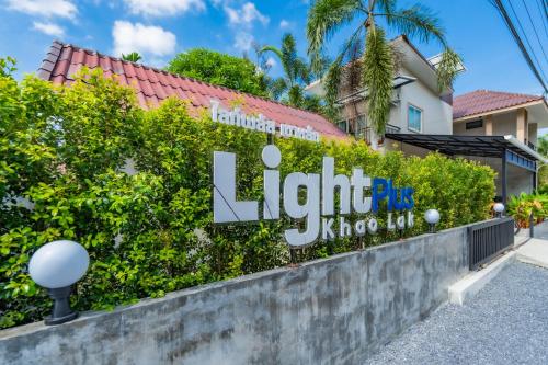 a sign for a hotel in front of a building at Lightplus Khao Lak in Khao Lak