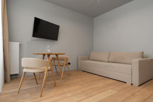 a living room with a couch and a table at SAVOIE Apartments Bukovel in Bukovel