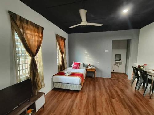 a living room with a bed and a flat screen tv at 1 Hati Homestay Sepang in Sepang