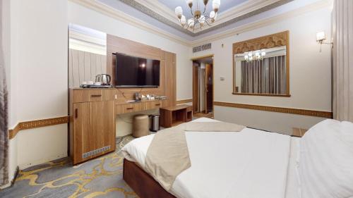 a hotel room with a bed and a television at Rama Al-Madina Hotel in Al Madinah