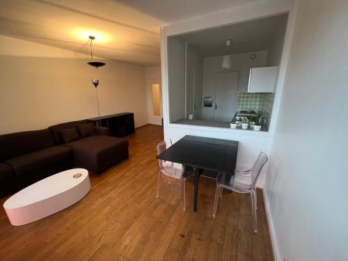 a living room with a table and a couch at Appartement lumineux 2 pièces Paris – idéal famille in Paris