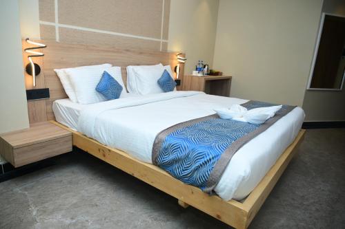 a large bed with a wooden frame in a bedroom at Pipul Ocean View Resort in Puri