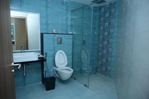 a bathroom with a toilet and a shower and a sink at Pipul Ocean View Resort in Puri
