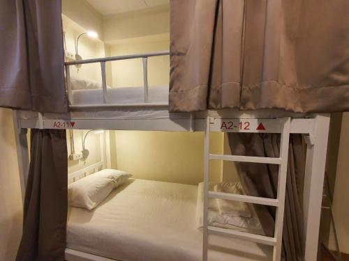 a bunk bed with a ladder in a room at Allred Hostel Chiangmai in Chiang Mai