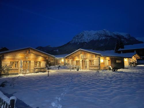 a log cabin in the snow at night at Chalets Alpglück in Oberstdorf
