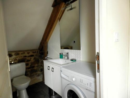een badkamer met een wastafel, een toilet en een spiegel bij LOFT au cœur de Bécherel in Bécherel