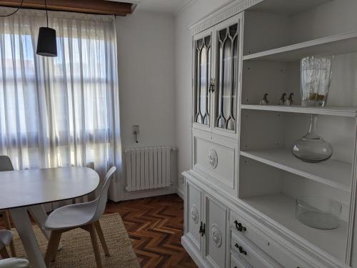 uma sala de jantar com uma mesa e um armário branco em Mirador de Ferradores em Betanzos