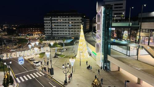 una vista de la ciudad por la noche con un árbol de Navidad en Vetusta Nest, en Oviedo