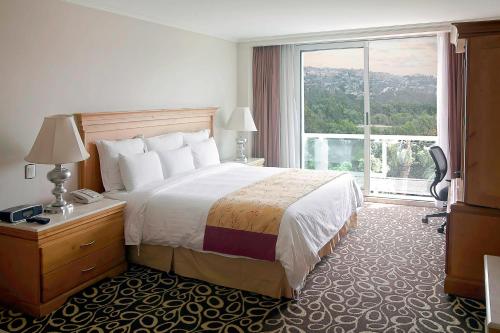 um quarto de hotel com uma cama e uma grande janela em Marriott Tijuana Hotel em Tijuana