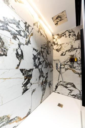 a bathroom with a marble wall at INFINITVM in Sigüenza