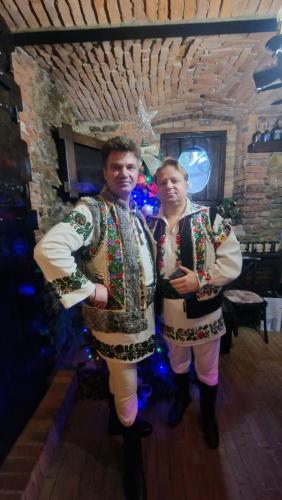 two people in christmas costumes standing in a room at Casa Domnească Rarau in Câmpulung Moldovenesc