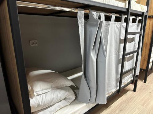 a black bunk bed with white sheets and pillows at Hostel O2 in Almaty