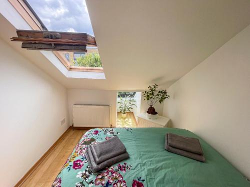 1 dormitorio con 1 cama grande y ventana grande en 1 Bed Attic Flat with Easy Reach to City Centre, en Londres